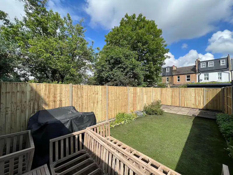 New fence run alongside a lawn and decking
