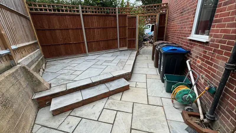 Fence panels with trellis tops above a sandstone patio